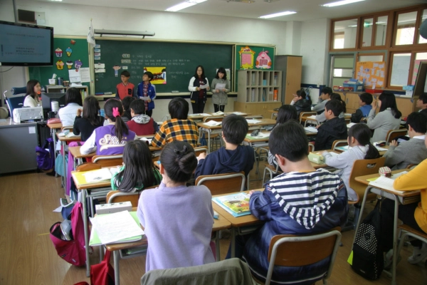 Students seated in a classroom during a lesson. Teacher supporting students in a classroom setting
